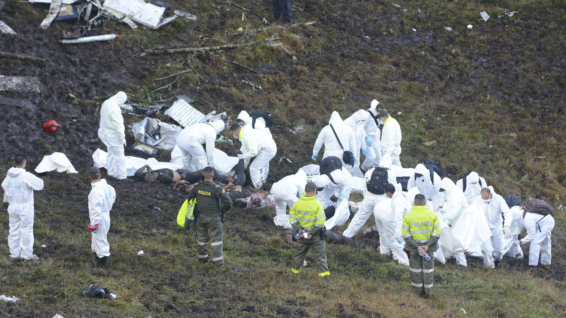 Rescue workers arrange the bodies of victims of an airplane that crashed in La Union, a mountainous area outside Medellin, Colombia, Tuesday , Nov. 29, 2016. The plane was carrying the Brazilian first division soccer club Chapecoense team that was on it's way for a Copa Sudamericana final match against Colombia's Atletico Nacional. (AP Photo/Luis Benavides)