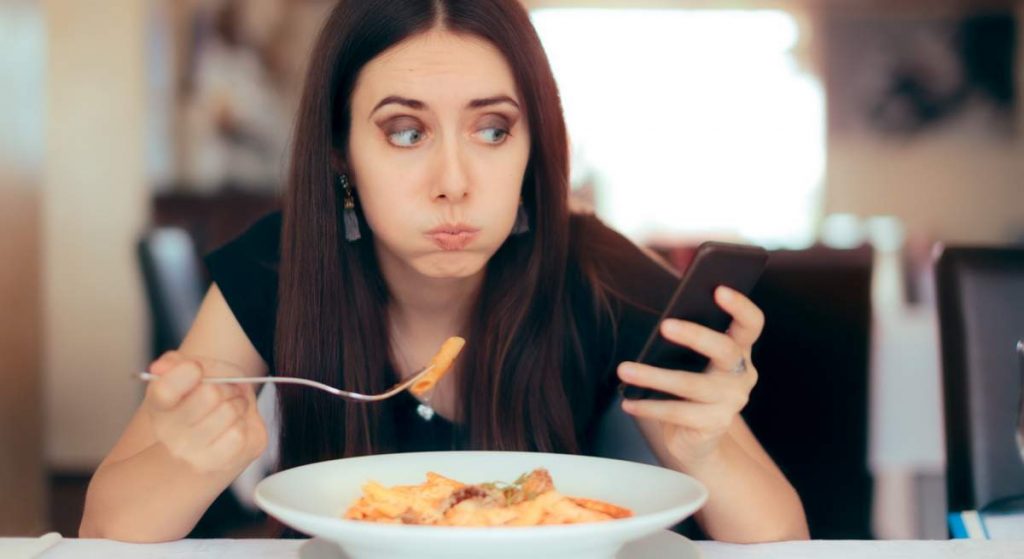 Usar el celular mientras comes te hace sentir menos saciado