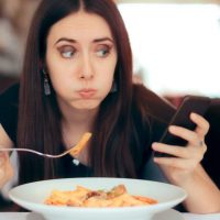 Usar el celular mientras comes te hace sentir menos saciado